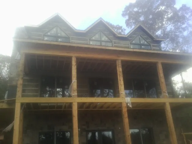 Dormers and porch framing on a large log home under construction — Roof Coating work by our crew in Pequannock