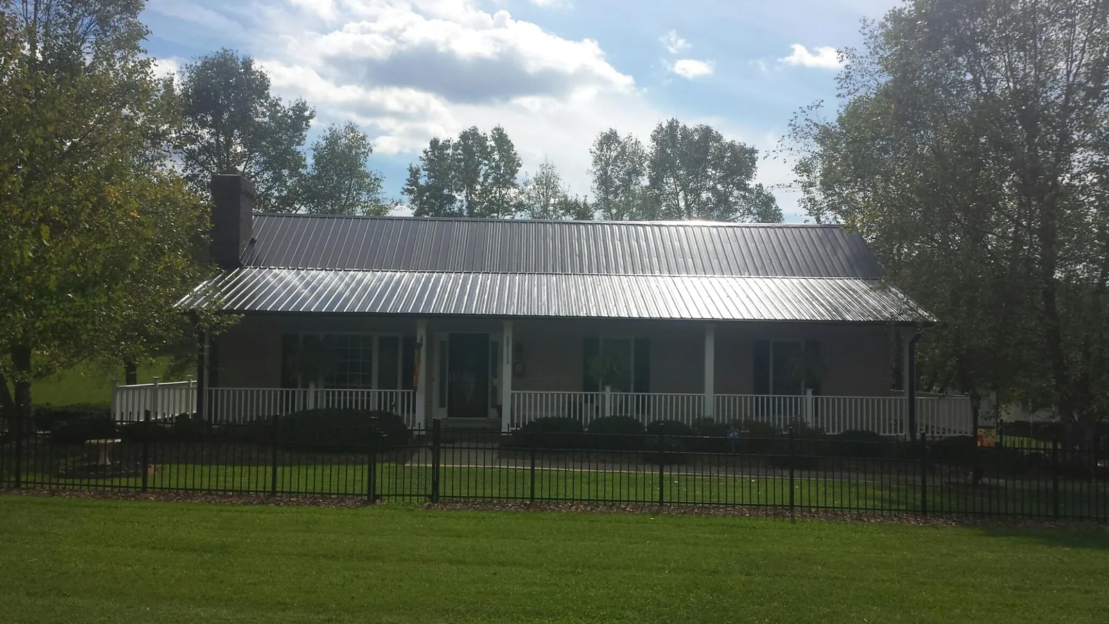 Gray metal roof on a brick ranch with a full width front porch — Gutter Guard Installation work by our crew in Pequannock